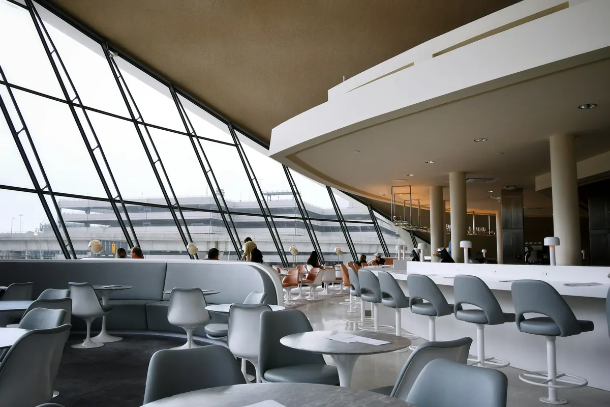 Private terminal lounge with armchairs and tall windows onto the airfield