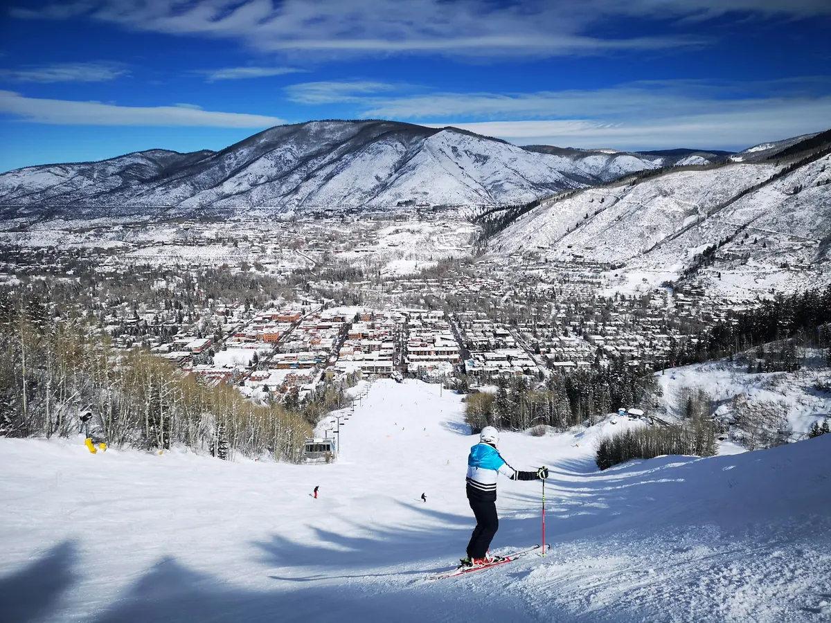 A skier above the snow-covered town of Aspen